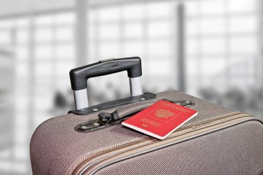 Havaalanı terminalinde pasaportlu bavul. Arka plan bulanık. Macera ve seyahat konsepti.