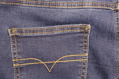 Üzerinde çiviler olan mavi moda kotların dikişli arka cebi.