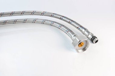 Hafif arka planda bağlantıları olan esnek su hattı. Tesisat aksesuarları.