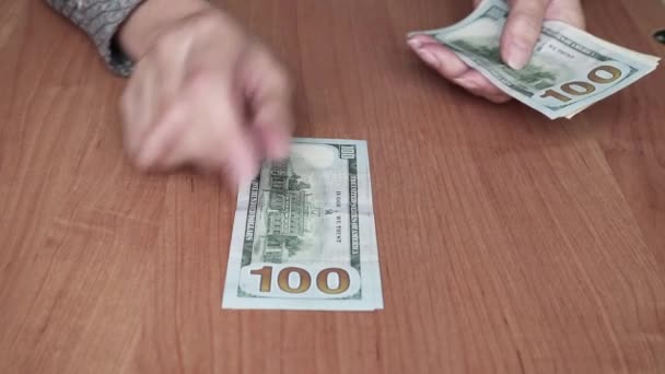 Las manos de las mujeres ponen billetes de dólar americanos en pilas. Cuenta el dinero. — Vídeos de Stock