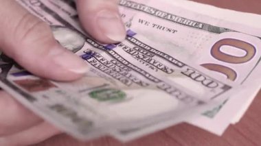 Bir kadın dolar sayıyor, Amerikan paralarını düzenliyor. Eller yukarı..