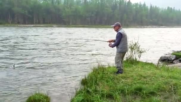 一位渔夫在山河里用纺锤钓到了一条鱼 灰白色的渔获物 — 图库视频影像