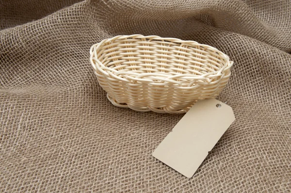 Пустой плетеной корзине на фоне ткани — стоковое фото
