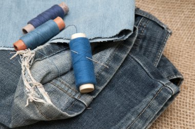 Çuval bezi bir arka plan üzerinde kot pantolon yırtık eski.