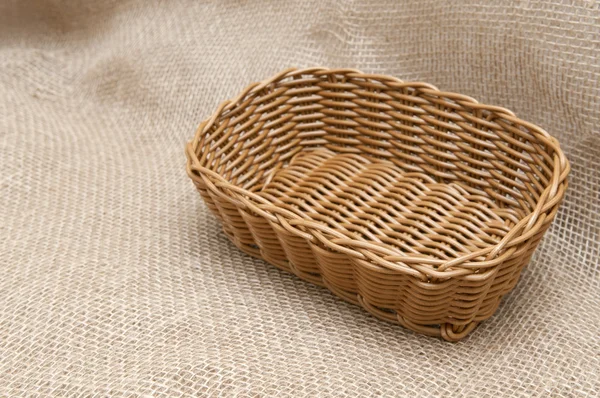 Пустой плетеной корзине на фоне ткани — стоковое фото