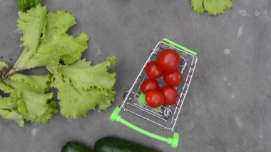 Gri kumaşın arka planında sebze rotasyonu olan market sepeti.