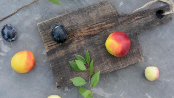 Drewniana antyczna deska do siekania i owoce na stole. Obróć kamerę w kółko. — Wideo stockowe