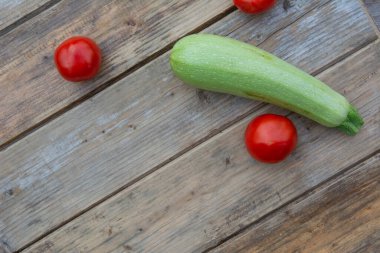 Ahşap bir masa arkasında domates ve kabak.
