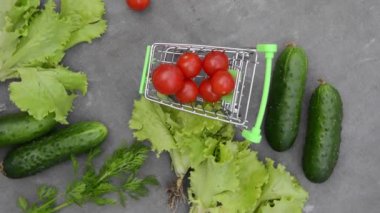 Gri kumaşın arka planında sebze rotasyonu olan market sepeti.