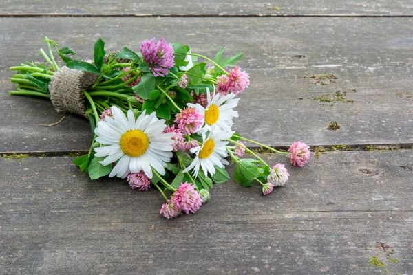 Bouquet of wildflowers with daisies on an old wooden table. — Stock Photo, Image