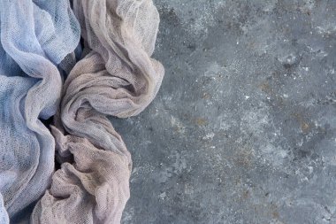  Gri dokulu yüzeyde iki renkli açık renk kumaş. Boşluğu kopyala.