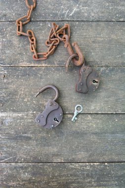 Ahşap arka planda iki eski paslı asma kilit ve paslı zincir. Çift ilişkisi kavramı. 