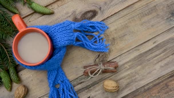 Winterstilleven met dennentakken, koffiekop gewikkeld in een gebreide sjaal op een houten tafel — Stockvideo