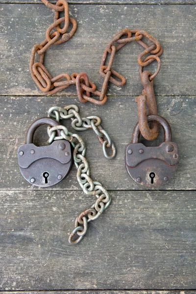 Deux vieux cadenas rouillé et chaîne rouillée sur fond en bois. Le concept de relation de couple — Photo