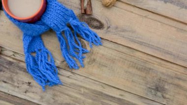 Çam dallarıyla sakin bir hayat, ahşap bir masanın üzerinde örülmüş bir eşarba sarılı kahve fincanı