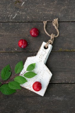 Ahşap masanın üzerinde yaprakları olan taze erikler. Boşluğu kopyala