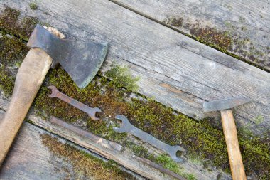 Kalasların arka planına balta ve çekiç ile yosun kaplı antika aletler. Boşluğu kopyala