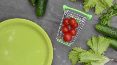 Vegetables, a plate and a shopping trolley against the background of an old rag