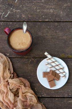 Bir fincan kahve, bir parça çikolata ve tahta bir masaya yapıştırılmış çubuklar. Tatlı. Boşluğu kopyala