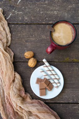 Bir fincan kahve, bir parça çikolata ve tahta bir masaya yapıştırılmış çubuklar. Tatlı. Boşluğu kopyala