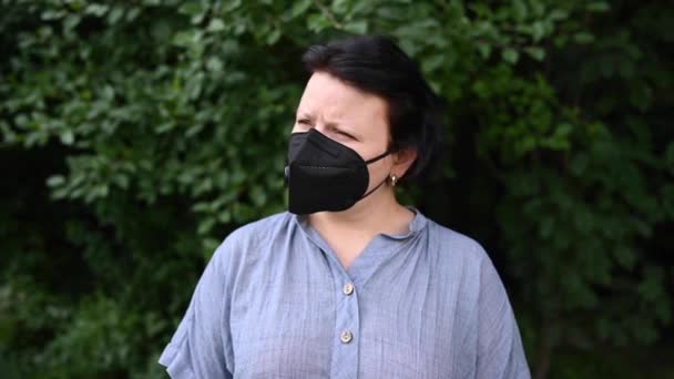 Kvinna i medicinsk mask utomhus. Statisk kamera. — Stockvideo