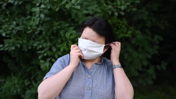 Mujer al aire libre. Corrige la máscara médica blanca al aire libre. El concepto de protección contra el covidio. — Vídeos de Stock