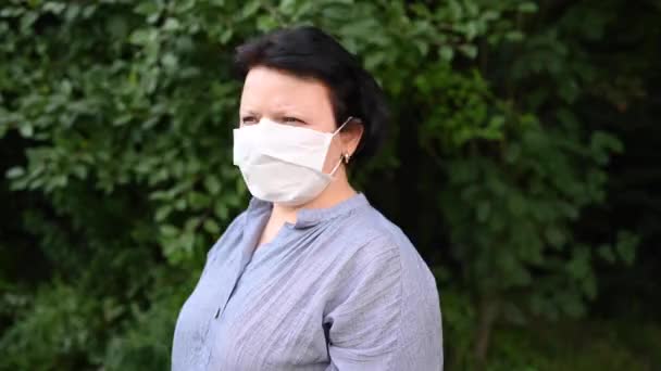 Une femme avec un masque médical lève la tête, lève les yeux. Un respirateur noir. Vidéo concept pandémique 4k — Video