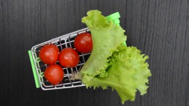 Marul sepetinde marul ve kiraz domatesleri. Video kamera döndürmesi.