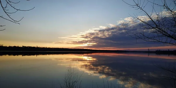 Nehir kıyısında, gökyüzünde gün batımı