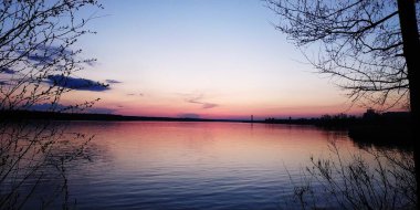 Nehir kıyısında, gökyüzünde gün batımı