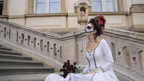 Chica con maquillaje de Halloween y Santa muerte, con rosas en las manos. — Vídeos de Stock