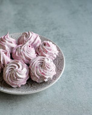 Bir el, arka planda şekerlemeler olan pembe bir lokum tutar. Lezzetli tatlılar, tatlı, sağlıklı ev yapımı tatlılar.