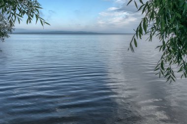Nehirde gün batımı. Bir yaz akşamı su yüzeyinin ufuk çizgisine bakışı.