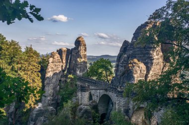 Kayalık oluşum ülkesinde köprü. Sakson İsviçre (Almanya), eşsiz dağları, kayaları ve bitki örtüsüyle ünlü ve çok güzeldir. Dağlarda sis var. Yaz güneşli bir gün