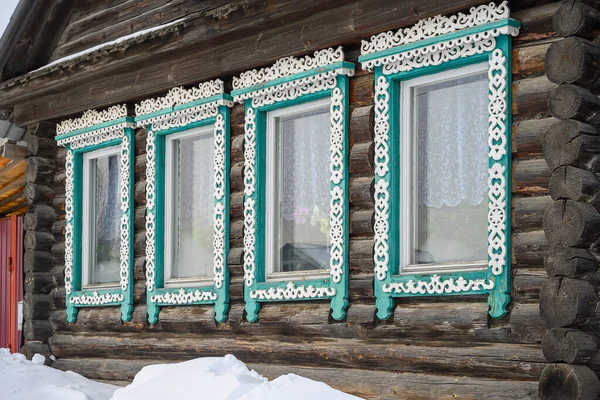 window in the house. windows with colored, carved wooden shutters in a rustichous e. close-up. eco-friendly housing for people with wooden artistic elements. winter sunny day