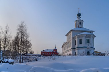 Karda eski bir kilise. Cherdyn 'de kış (Kuzey Urallar, Rusya). Alçılı, kıvırcık saçlı, zengin bir dekorasyon. Kule 'nin tepesinde. Parlak renkler. Yerdeki kalın kar tabakası. Mavi gökyüzü, güneşli gün.