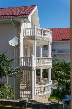 Güzel beyaz balkonları ve palmiyeleri olan deniz kenarındaki modern bir ev. Denizde tatil. 