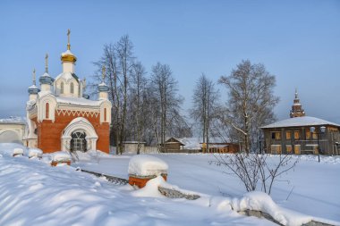 Kışın Cherdyn şehrinin (Kuzey Urallar, Rusya) tarihi merkezine bakın. Kubbeli kiliseler, eski ahşap bir ev ve karda bir kemer. Yüksek kar yağışı neredeyse tüm çiti gizliyor. 