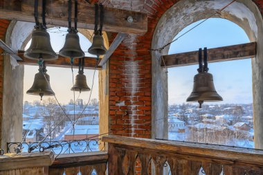 Buz gibi bir kış gününde uzun tuğla bir çan kulesinin tepesine vintage çanlar döşemek. Çan kulesi inşaatı Çan kulesindeki açıklıklardan Cherdyn 'in (Rusya) harika taşra şehrini görebilirsiniz.) 