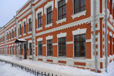 Eski kadın spor salonunun eski beyaz ve turuncu tuğlalı binası. Yakın plan. Kalıplar tuğladan yapılmış. Geleneksel Rus tarzı taş ve tuğla mimari. Kış günü 