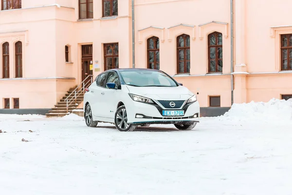 Aluksne, Letonya - 01.12.2021 Metalik beyaz Nissan Yaprağı. Nissan 'ın ürettiği beş kapılı hatchback elektrikli araba. Sıfır emisyon arabası