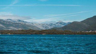 Akdeniz 'in arka planında dağlar ve mavi sularıyla güzel bir manzara.