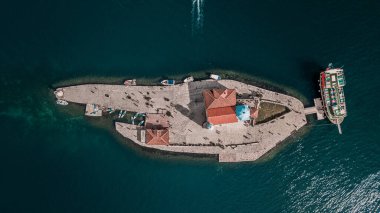 Karadağ, Avrupa 'daki Boka Kotor körfezi kıyısındaki Kaya Adası Leydisi ve Perast Kilisesi. Dik raket tahtaları ve turistlerle hava manzarası