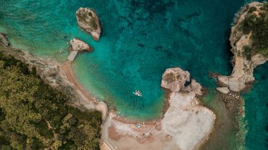 Budva 'daki Aziz Niklas adasındaki plaj ve uçurum, Karadağ' ın sularındaki SUP kürekçileri ayakta tutuyor. Denizde bir adadaki cennet kumsalı