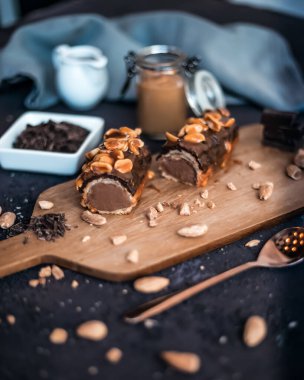 Geleneksel Fransız tatlı ekininde siyah çikolata ve fıstıkla ahşap bir tahta ve bir kafede ya da restoranda bir masa üzerinde kompozisyon.