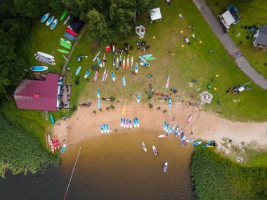 İnsansız hava aracından harika bir göl manzarası. İnsanların SUP ile kürek çektiği bir yaz günü.