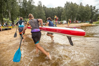 Kalk ayağa SUP yarış rakipleri. SUP festivalinde insanlar ejder raketleriyle kürek çekiyor. muhteşem aktif açık hava eğlencesi.