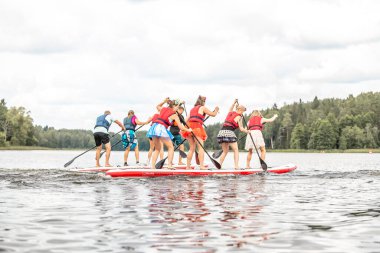 Kalk ayağa SUP yarış rakipleri. İnsanlar SUP festivalinde Ejderha tahtalarıyla kürek çekiyor. Muhteşem aktif açık hava eğlencesi. SUP panolarında dört kişi