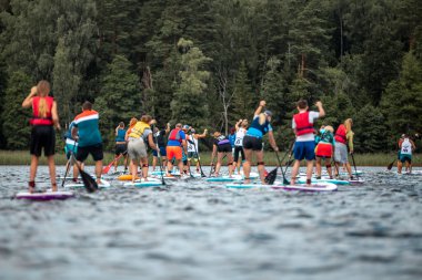 İnsanlar kürek çekip gölde kürek çekiyorlar. SUP yarışması, yarış. muhteşem aktif açık hava eğlencesi.
