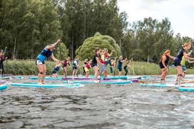 İnsanlar kürek çekip gölde kürek çekiyorlar. SUP yarışması, yarış. muhteşem aktif açık hava eğlencesi.